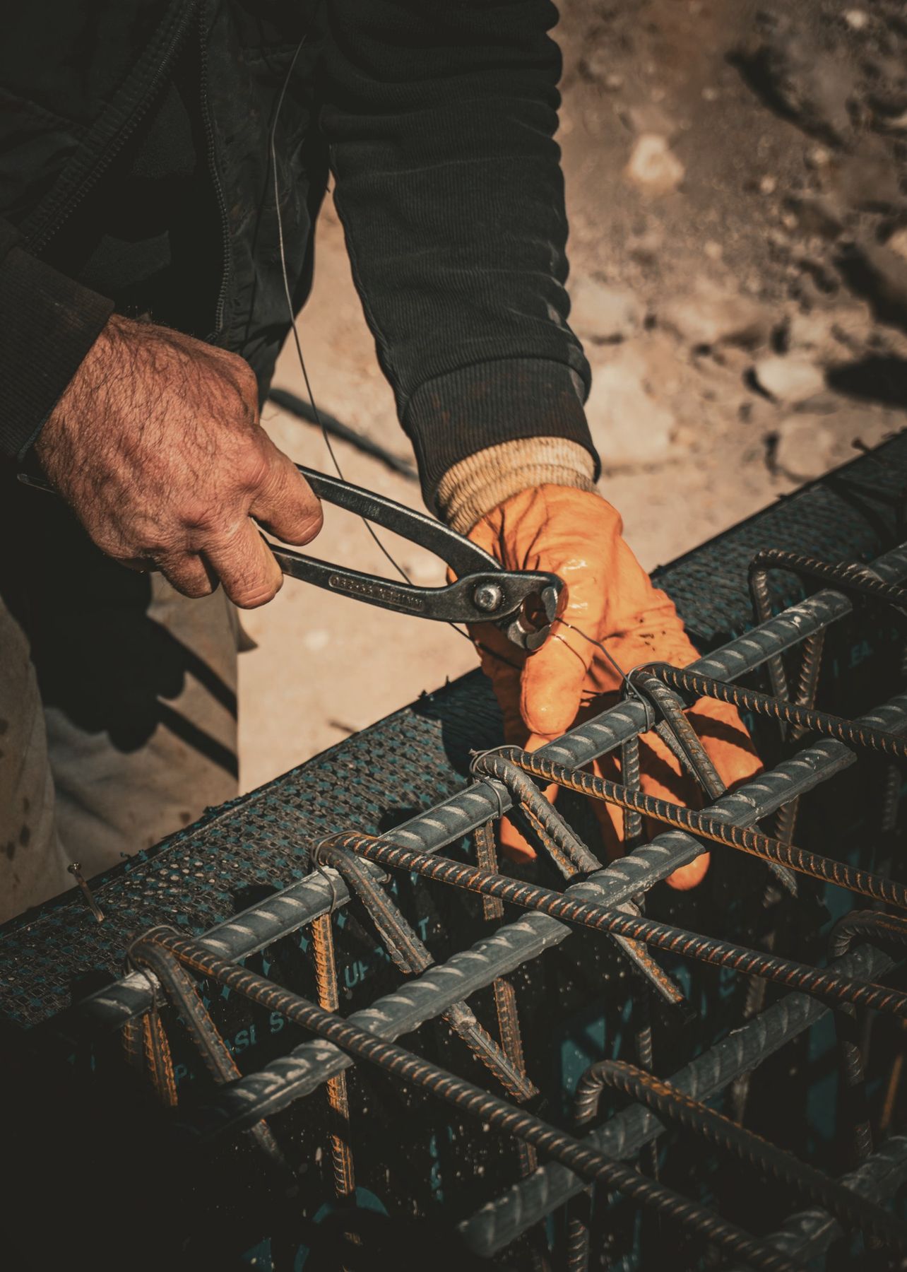 Punëtor lidh armaturën e një trari me pinca